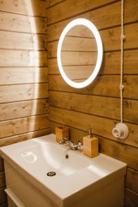 uma casa de banho com um lavatório e um espelho em Forrest Lodge Karelia em Reuskula