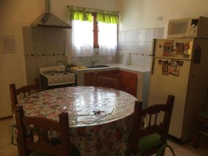 
a kitchen with a table and chairs and a refrigerator at Unsleben in Villa Carlos Paz

