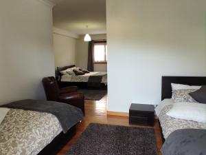 um quarto com duas camas e uma cadeira em Casa das Bocelinhas em Arouca