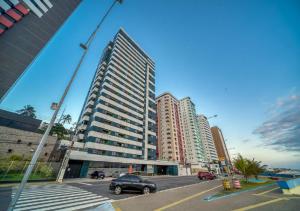 a tall building with a car parked in a parking lot at Golden Tower in Natal