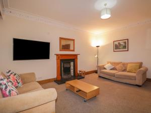 sala de estar con 2 sofás y chimenea en Kinnaird House, en Grantown-on-Spey