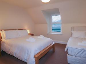 1 dormitorio con 2 camas y ventana en Kinnaird House, en Grantown-on-Spey