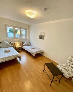 uma sala de estar com duas camas e uma cadeira em Gemütliches WG-Zimmer 5, zentral in Ravensburg (stadtnah) em Ravensburg