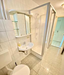 uma casa de banho com um WC, um chuveiro e um lavatório. em Gemütliches WG-Zimmer 5, zentral in Ravensburg (stadtnah) em Ravensburg