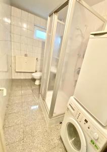 uma casa de banho com uma máquina de lavar roupa e um WC em Gemütliches WG-Zimmer 5, zentral in Ravensburg (stadtnah) em Ravensburg