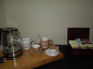 a coffee maker and cups on a wooden table at Casa das Bocelinhas in Arouca