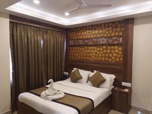 a bedroom with a bed with a wooden headboard at Hotel White Boutique in Pondicherry