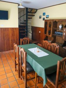 a dining room with a green table and chairs at Departamentos Arco Iris Tandil in Tandil +17 photos