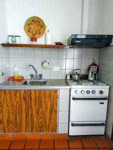 cocina con fogones blancos y fregadero en Departamentos Arco Iris Tandil en Tandil