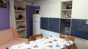 uma cozinha com uma mesa e um frigorífico branco em Casa Alpina - Mototurismo em Susa