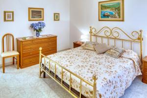 sypialnia z łóżkiem i komodą oraz wazonem kwiatów w obiekcie ELENA House w mieście Levanto