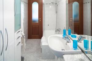 bagno bianco con lavandino e specchio di ELENA House a Levanto