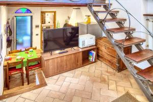 a living room with a television and a ladder at MARIO Apartment with Garden in Levanto