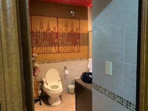 baño con aseo y una pintura en la pared en Quinta Ugarte en Ciudad Lujan de Cuyo