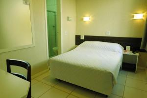 a hotel room with a bed and a desk at Hotel Elevado in Porto Alegre