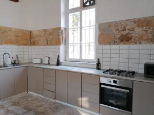 eine Küche mit weißen Schränken und einem Herd mit Backofen in der Unterkunft Le Mat Hostel in Larnaka