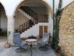 a patio with two chairs and a table and a staircase at Le Mat Hostel in Larnaca