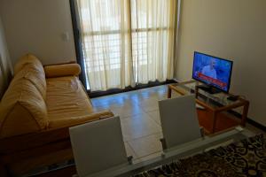 sala de estar con sofá y TV de pantalla plana en Balcones De La Riviera en Córdoba