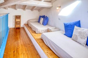 a bedroom with two beds and a wooden floor at IVANA Apartment in Levanto