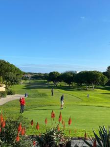 um grupo de pessoas a jogar golfe num campo de golfe em Algarve Luxury Experience - Situated within the Pinecliffs Resort em Albufeira