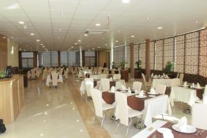 a restaurant with white tables and white chairs at Hotel Mauricenter Nouakchott in Nouakchott