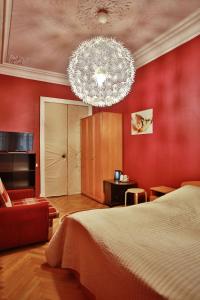 a bedroom with a bed and a chandelier at Fligel na Zhukovskogo in Saint Petersburg