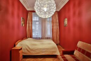 a bedroom with red walls and a chandelier at Fligel na Zhukovskogo in Saint Petersburg