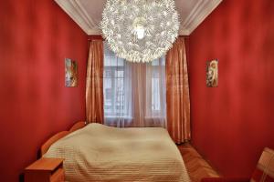 a bedroom with a chandelier and red walls at Fligel na Zhukovskogo in Saint Petersburg