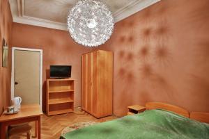 a bedroom with a bed and a chandelier at Fligel na Zhukovskogo in Saint Petersburg