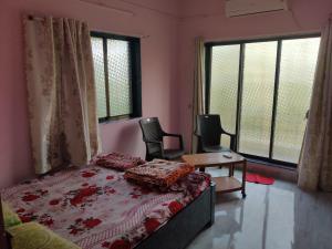 Postel nebo postele na pokoji v ubytování Gulmohar Cottages - Home Stay in Alibag
