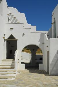 
a white building with stairs leading up to it at Anthea Hotel in Tinos Town
