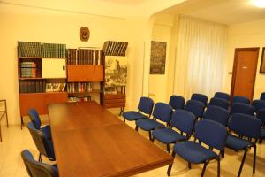 una sala de conferencias con una mesa de madera y sillas azules en Casa Piccole Ancelle di Cristo Re, en Roma