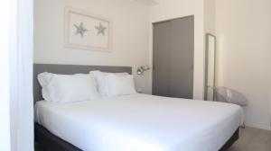 a white bed with white pillows in a bedroom at Hotel Mar Bravo in Nazaré