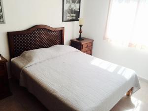 a bedroom with a bed and a lamp and a window at Rinconada del Sol in Playa del Carmen