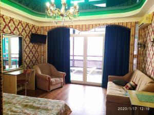 sala de estar con cama y lámpara de araña en Divo Guest House near sea, en Otradnoe