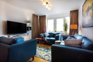 a living room with blue couches and a flat screen tv at Deluxe City Center Blue apartment in Split