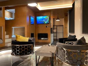 a living room with two chairs and a tv at Eleanor Rigby apts Stanley Street in Liverpool
