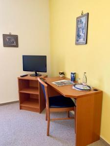 a desk with a television and a computer on it at Parkhotel Pretzsch in Bad Schmiedeberg