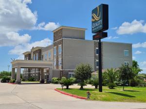 a building with a hotel sign in front of it at Quality Inn & Suites Victoria East in Victoria