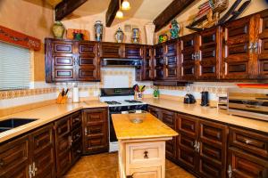 a kitchen with wooden cabinets and a stove top oven at Puesta del Sol by FMI Rentals in Puerto Peñasco