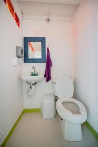 a white toilet sitting next to a white sink in a bathroom at Hostel Mexico DF Airport in Mexico City