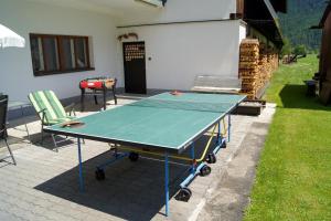 una mesa de ping pong y 2 sillas en el patio en Apartments Bauernhof Dismasn Hof, en Längenfeld