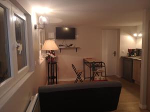a living room with a couch and a table at Charmante Maison studio proche mer et commerces in Ouistreham