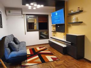sala de estar con sofá y TV de pantalla plana en Alojamiento Maria :-) en Córdoba