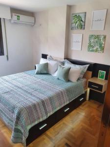 1 dormitorio con 1 cama con manta y almohadas en Alojamiento Maria :-) en Córdoba