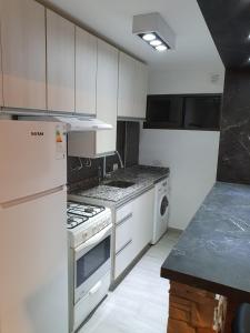a kitchen with white cabinets and a stove top oven at Alojamiento Maria :-) in Córdoba