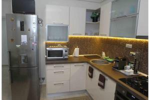 a kitchen with a stainless steel refrigerator and a microwave at The Apartment Sinaia in Sinaia