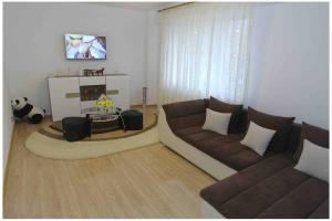 a living room with two couches and a panda bear at The Apartment Sinaia in Sinaia