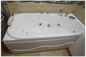 a white bath tub with a faucet in a bathroom at The Apartment Sinaia in Sinaia +6 photos