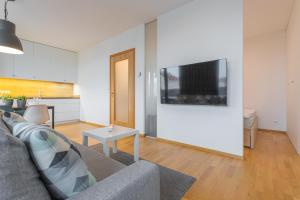 a living room with a couch and a tv on a wall at Apartment Oscar with garage in Prague